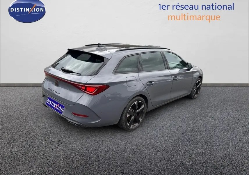 Vue 3/4 arrière droite d'une CUPRA LEON ST gris Graphene metal avec jantes noires bicolores sur fond neutre.