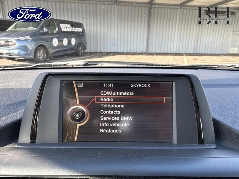 Écran multifonction central de BMW Série 1 114i 2013, affichant le menu radio, vue intérieure frontale.
