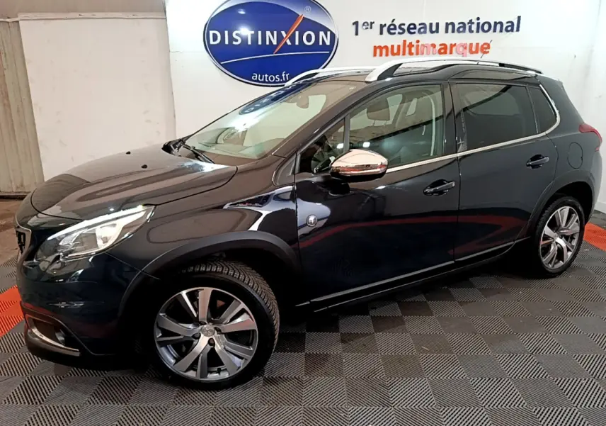 Peugeot 2008 gris foncé vue de profil côté gauche, avec jantes alliage et rétroviseurs chromés.