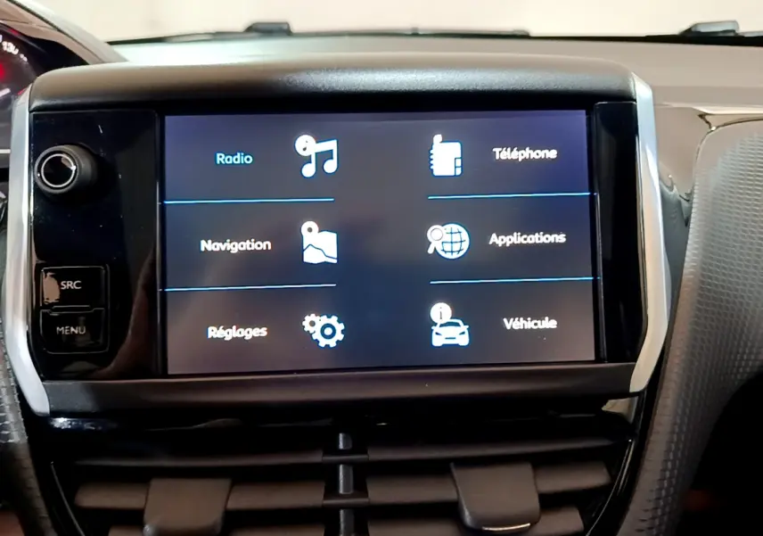 Écran tactile central affichant les menus radio, navigation et téléphone dans l'habitacle d'une Peugeot 2008 gris foncé.