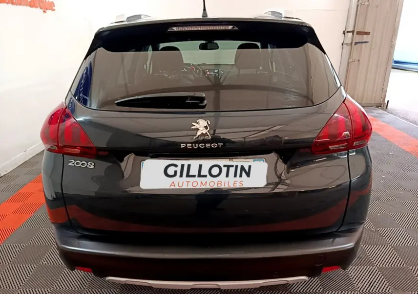 Vue arrière d'un Peugeot 2008 gris foncé avec feux arrière rouges et logo lion centré sur le hayon.