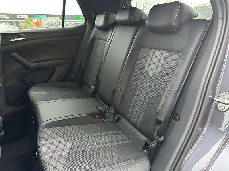 Vue intérieure des sièges arrière du Volkswagen T-Cross 2025 en gris Ascot, avec sellerie tissu et cuir au motif géométrique.