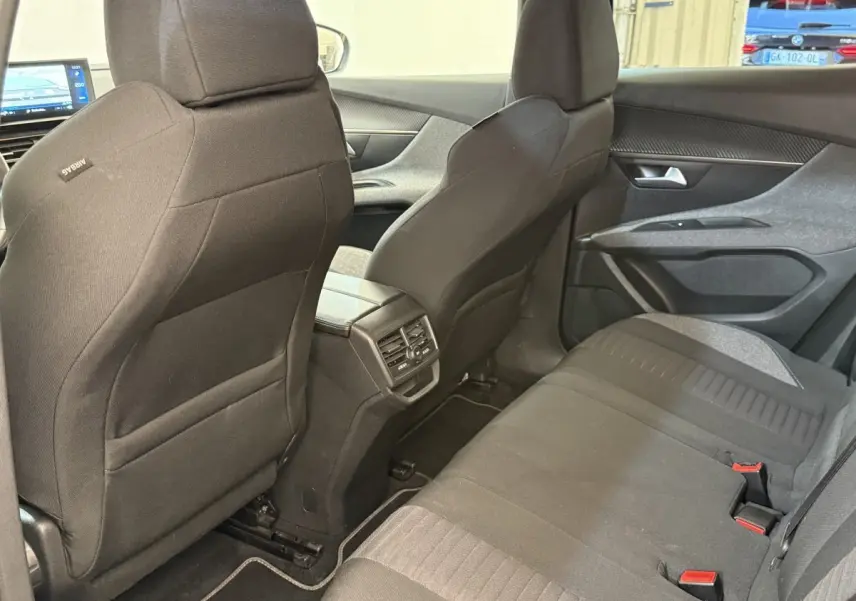 Vue intérieure arrière du Peugeot 3008 bleu 2021, sièges tissu noirs avec aérateurs centraux et portes côté droit.
