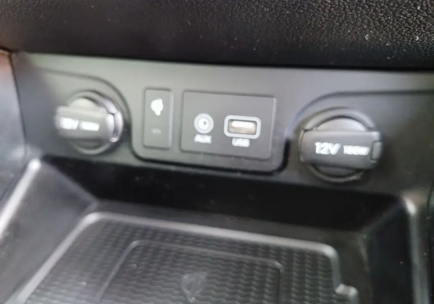 Vue rapprochée des ports USB, AUX et prises 12V du tableau de bord intérieur du Hyundai Tucson gris Micron.