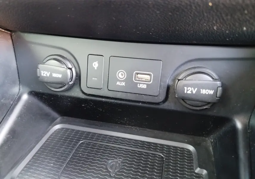 Vue rapprochée du panneau de connectiques USB, AUX, recharge sans fil et prises 12V du Hyundai Tucson Micron Grey 2019.