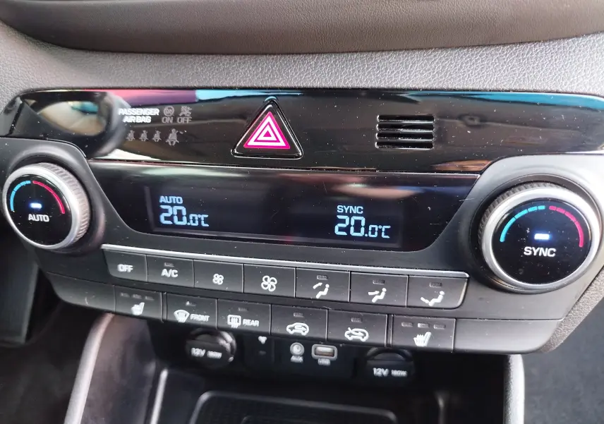Gros plan sur la console centrale du Hyundai Tucson 2019, affichant la climatisation digitale réglée à 20°C.