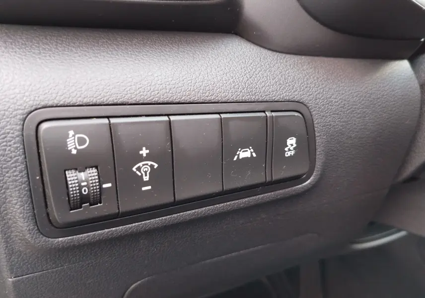 Gros plan sur les boutons de réglage d'éclairage et d'assistance à la conduite du tableau de bord gris foncé du Hyundai Tucson 2019.