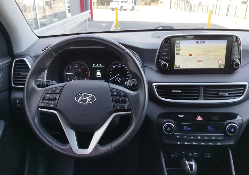 Vue intérieure du tableau de bord du Hyundai Tucson 2019, avec volant cuir, écran tactile et commandes de climatisation.