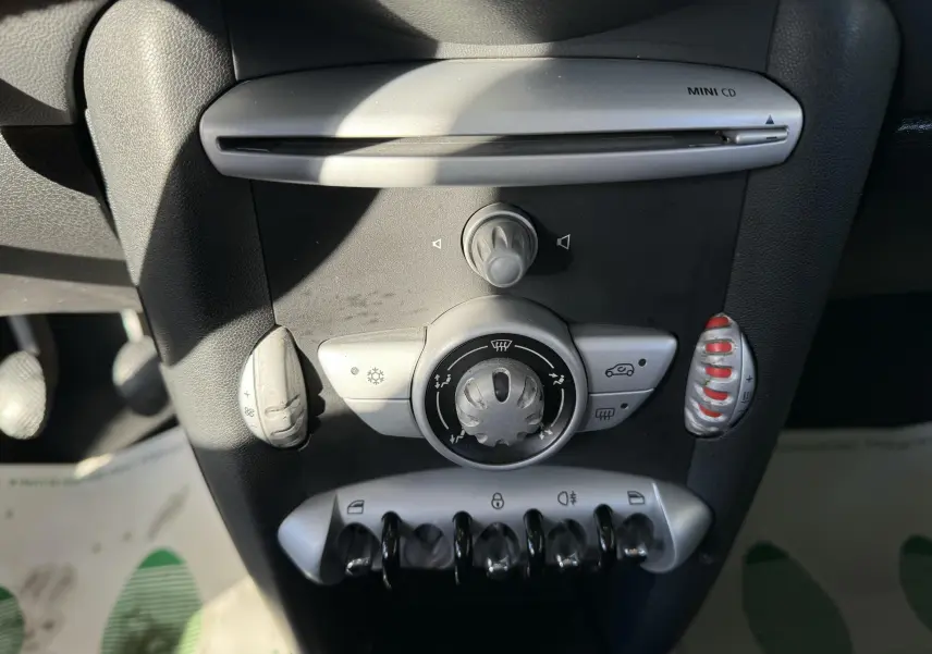 Gros plan sur la console centrale intérieure de la MINI Cooper 2007, montrant les commandes de climatisation et lecteur MINI CD.