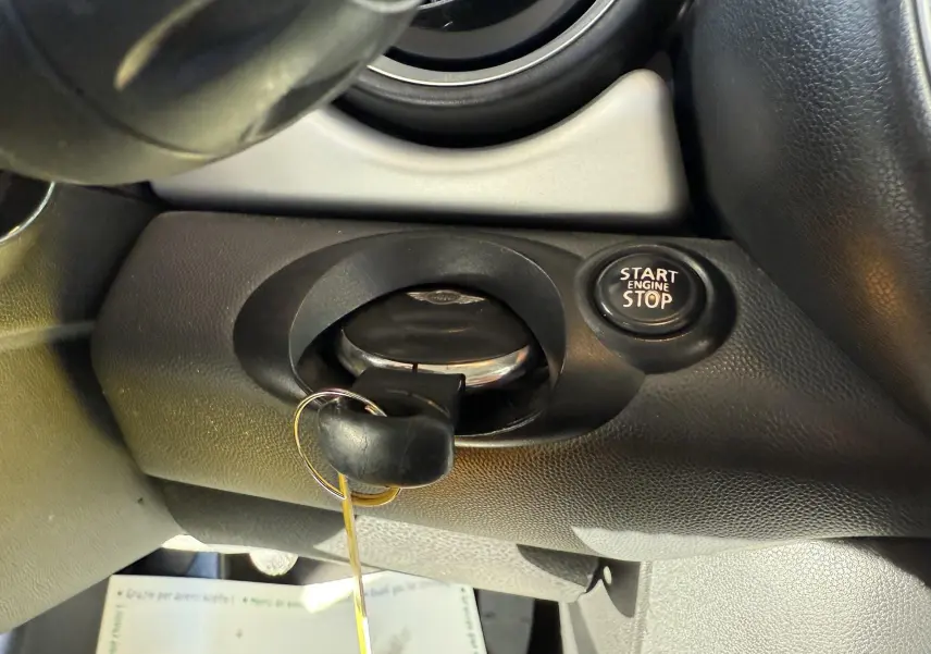 Gros plan sur le contacteur de clé et bouton start/stop dans l'habitacle d'une MINI Cooper bleu 2007.