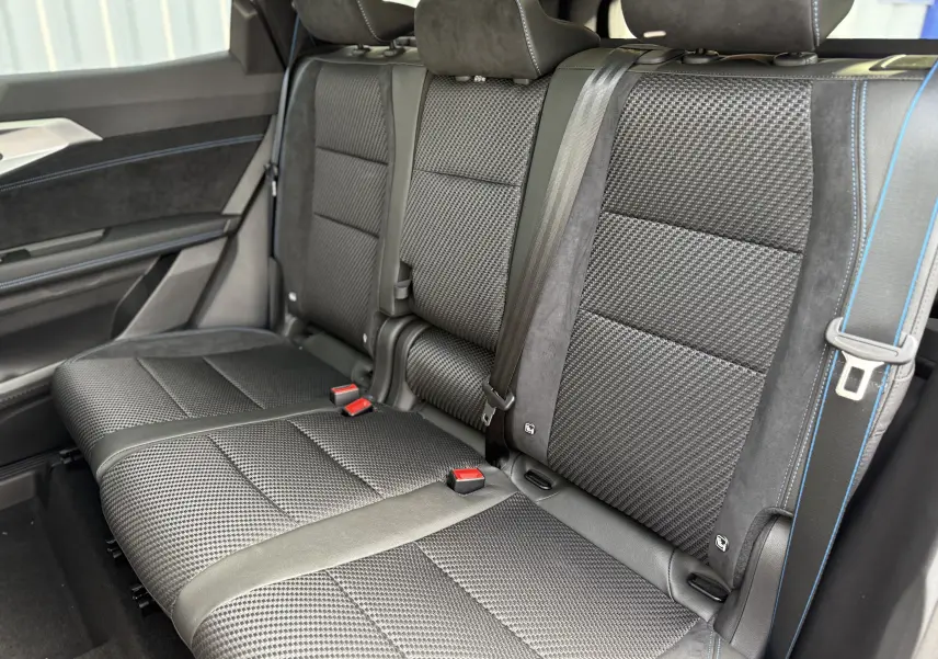 Vue latérale intérieure des sièges arrière noirs avec surpiqûres bleues du Renault Espace 2025 finition Esprit Alpine 7 places.