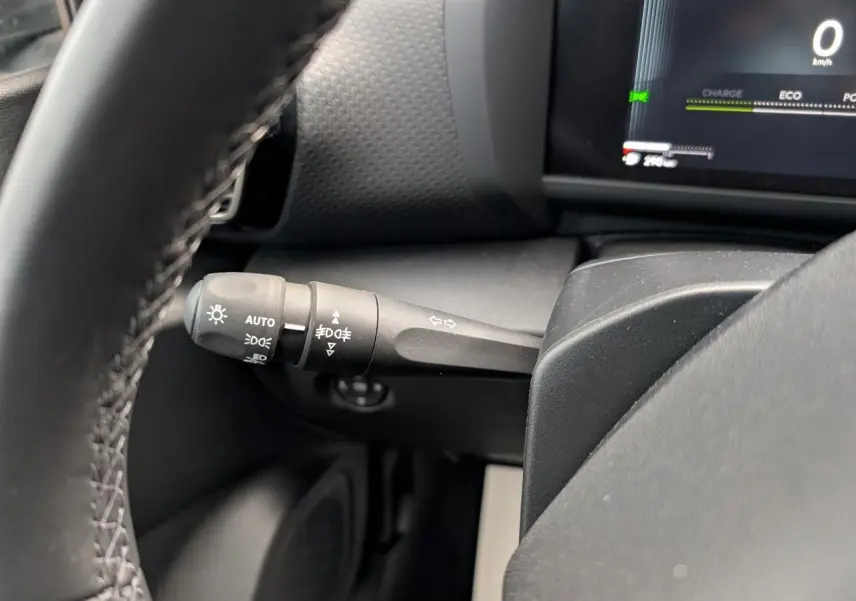 Gros plan sur la manette de commandes d’éclairage à gauche du volant dans l’habitacle du Citroën C4 blanc 2025