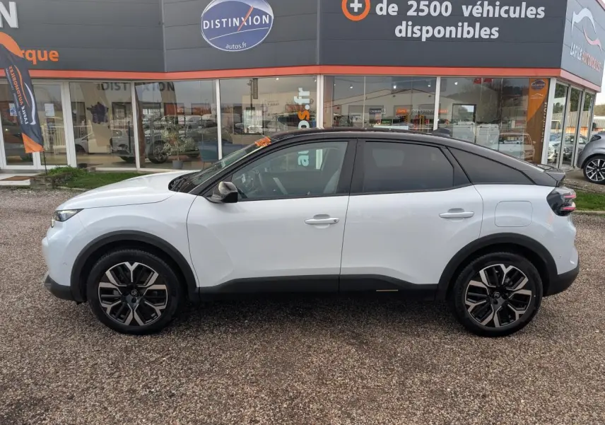 Profil côté gauche d'une Citroën C4 blanche 2025 avec toit noir bi-ton et jantes alliage 18 pouces.