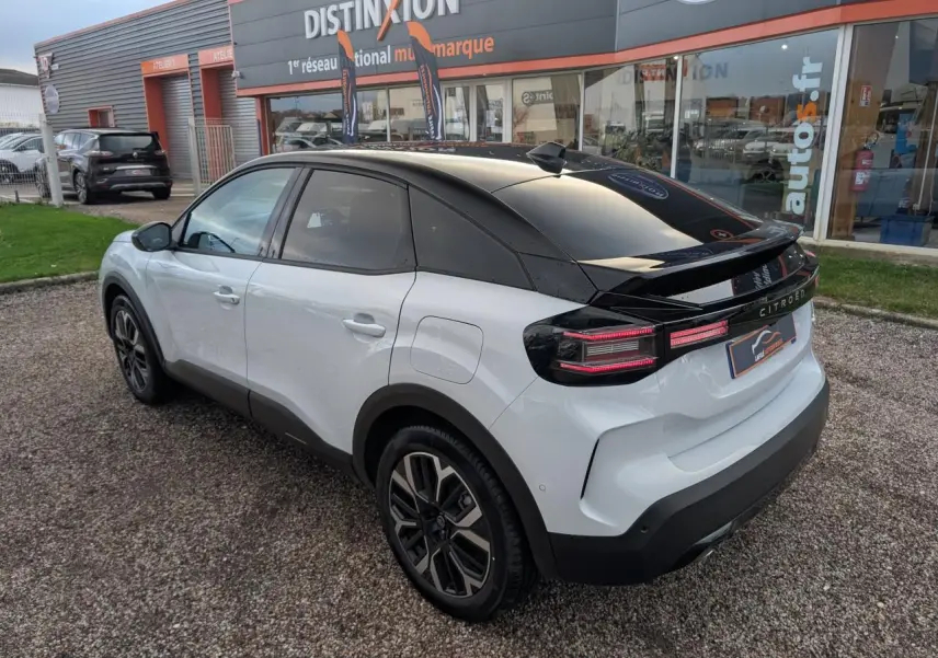 Vue 3/4 arrière droite d'une Citroën C4 blanche avec toit noir Perla Nera et jantes alliage 18 pouces.