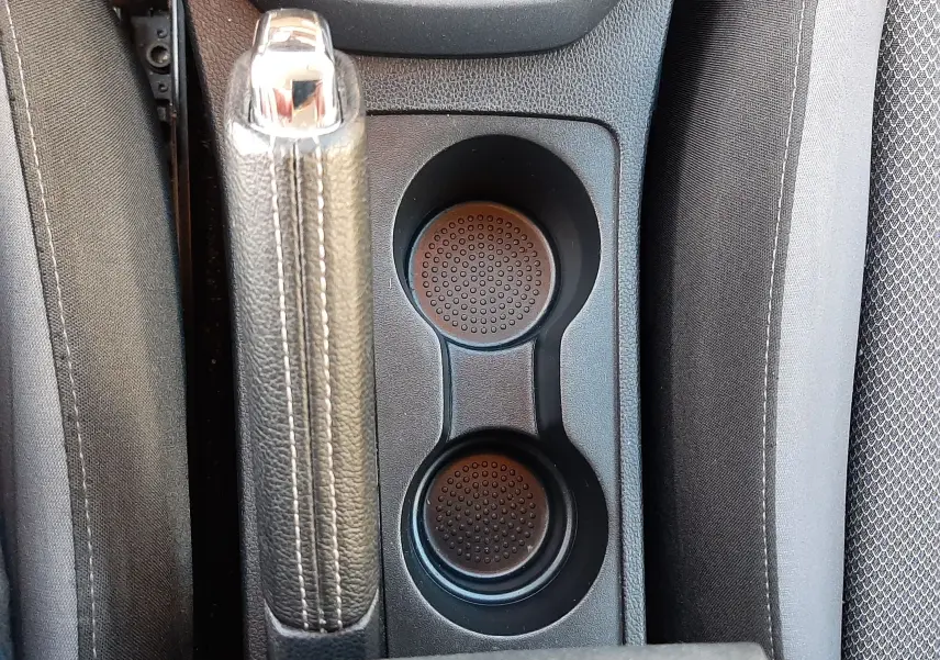 Vue plongeante sur la console centrale du SEAT ARONA 2019, montrant frein à main et porte-gobelets entre sièges gris.