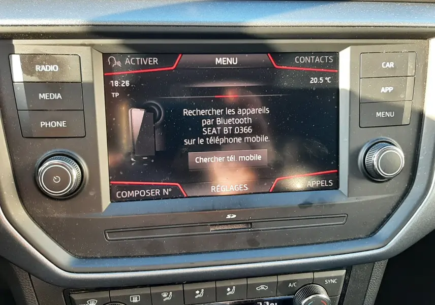 Vue rapprochée de l'écran tactile central et des commandes de climatisation du SEAT Arona gris magnetic avec toit noir.