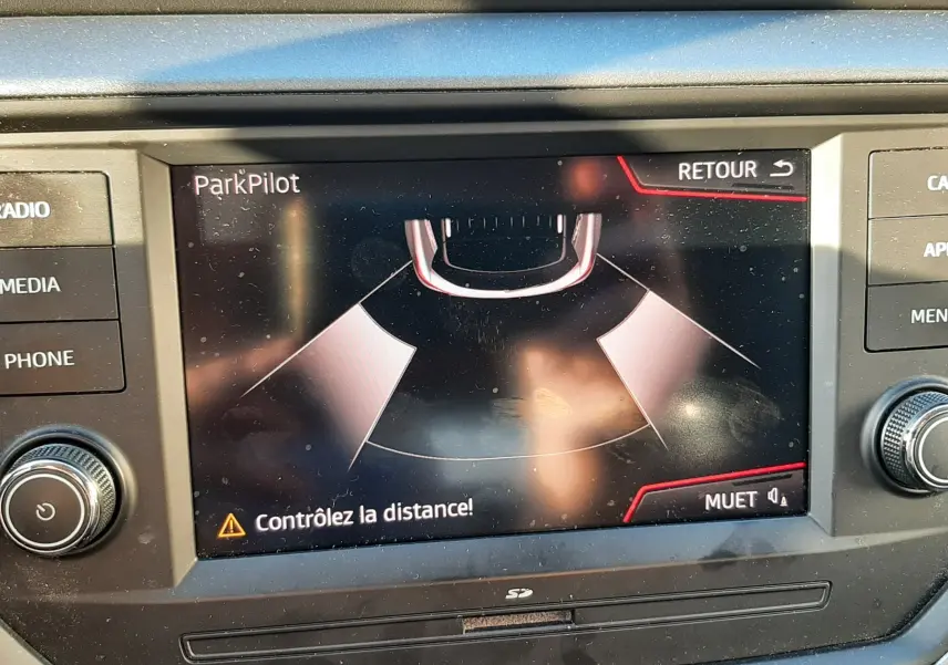 Écran central du tableau de bord d'une SEAT Arona 2019 affichant l'alerte ParkPilot pour le stationnement.