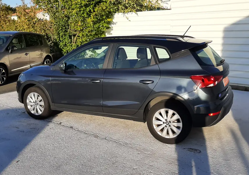 SEAT Arona gris magnetic avec toit noir, vue profil côté gauche, garée en extérieur au soleil.