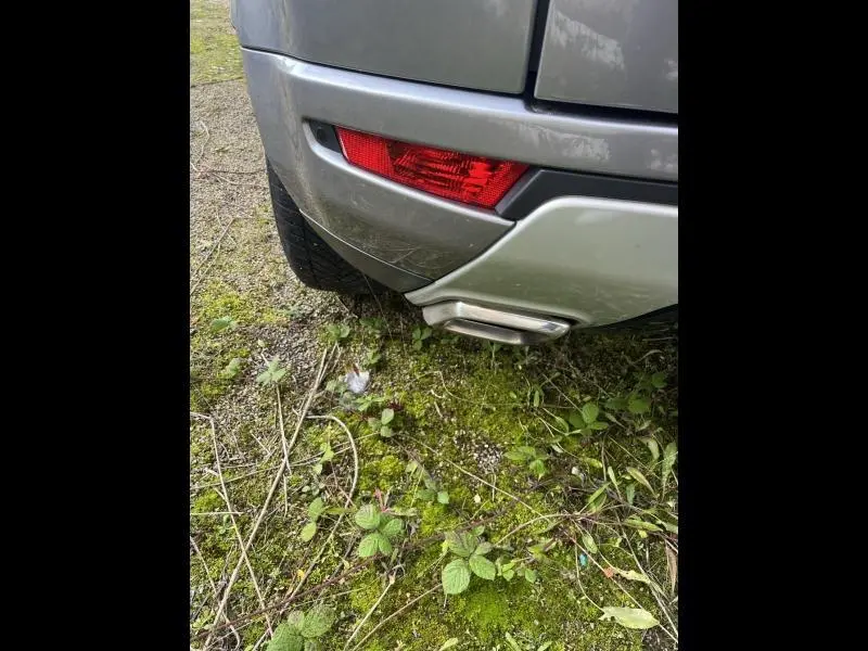Gros plan sur le coin arrière droit gris Orkney du Range Rover Evoque 2.2 Td4, avec feu rouge et sortie d’échappement chromée visible.