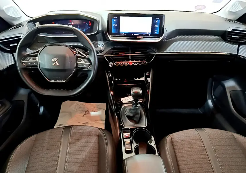 Intérieur de la Peugeot 208 PureTech 100 S&S Allure Business 2020, vue frontale du tableau de bord et volant cuir noir.