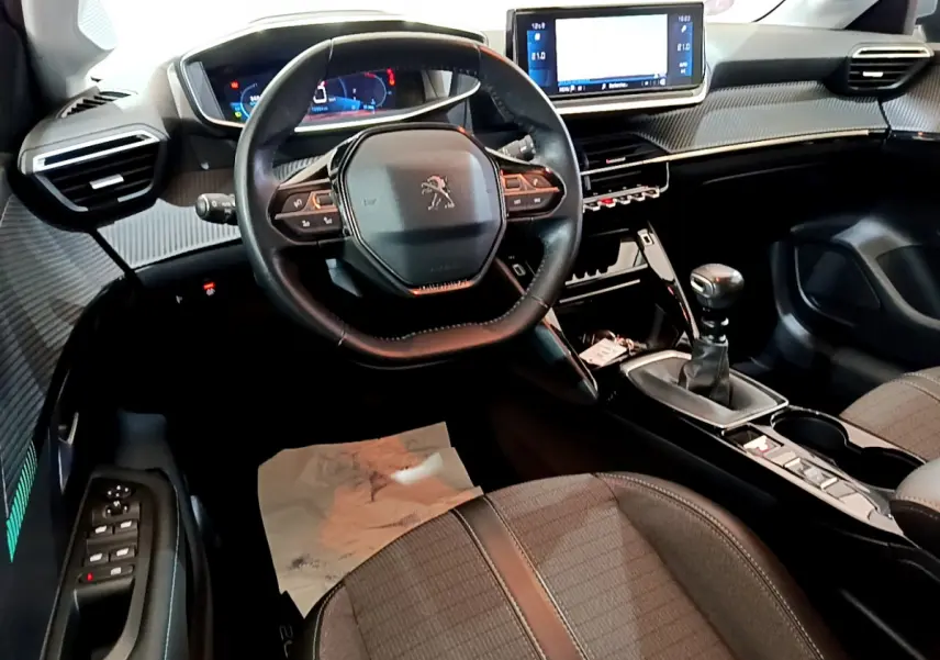 Intérieur de la Peugeot 208 PureTech 100 S&S Allure Business 2020, vue cockpit avec volant cuir et écran tactile central.