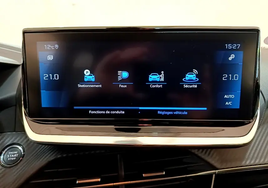 Écran tactile central affichant les réglages du véhicule dans une Peugeot 208 gris clair, vue intérieure frontale.