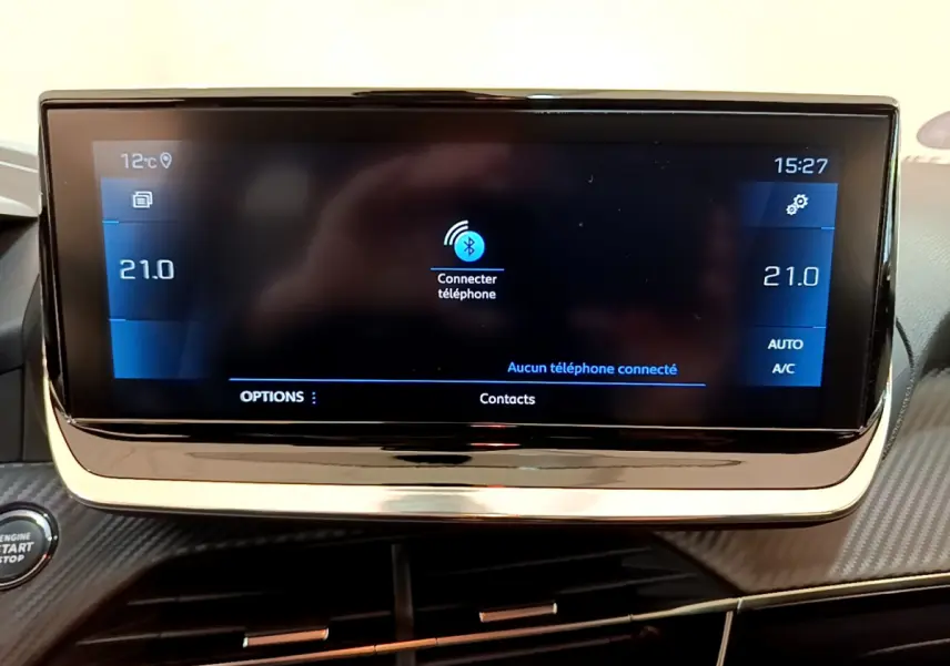Écran tactile central de la Peugeot 208 gris clair affichant la connexion Bluetooth et la température à 21°C.