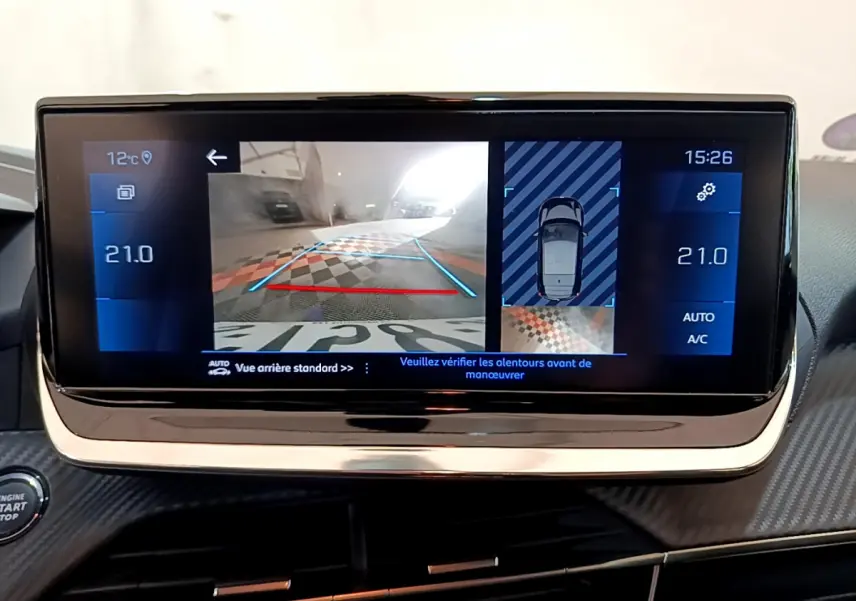 Écran tactile central de la Peugeot 208 gris clair affichant la caméra de recul et la température intérieure à 21°C.