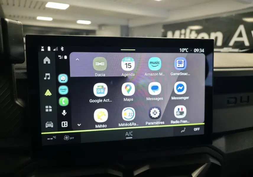 Vue rapprochée de l’écran tactile central 10 pouces du Dacia Duster 1.6 Hybrid noir, affichant les applications connectées.