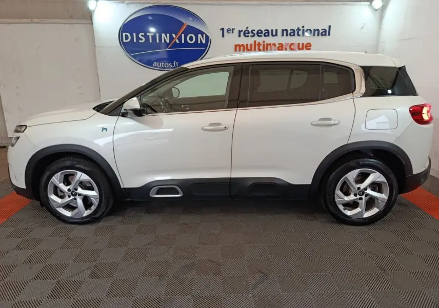 Profil droit d'un Citroën C5 Aircross Hybrid blanc, avec détails noirs contrastants et jantes alliage cinq branches.