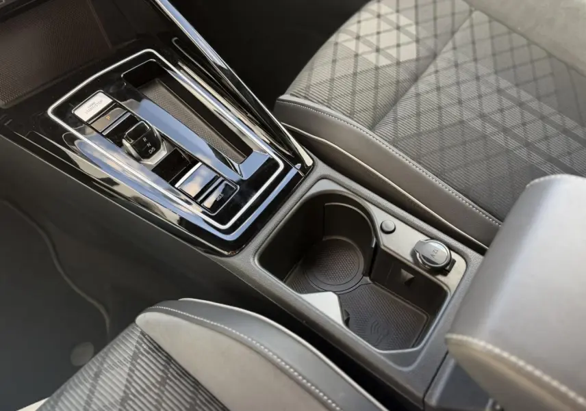 Gros plan sur la console centrale noire de la Volkswagen Golf 8 R-Line 2024 avec levier de vitesse et porte-gobelets.