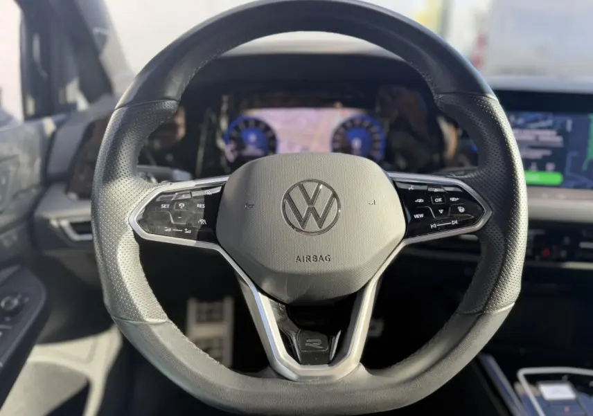 Volant sport noir avec logo VW, boutons multifonctions, vue frontale intérieure du Volkswagen Golf 8 R-Line 2024.
