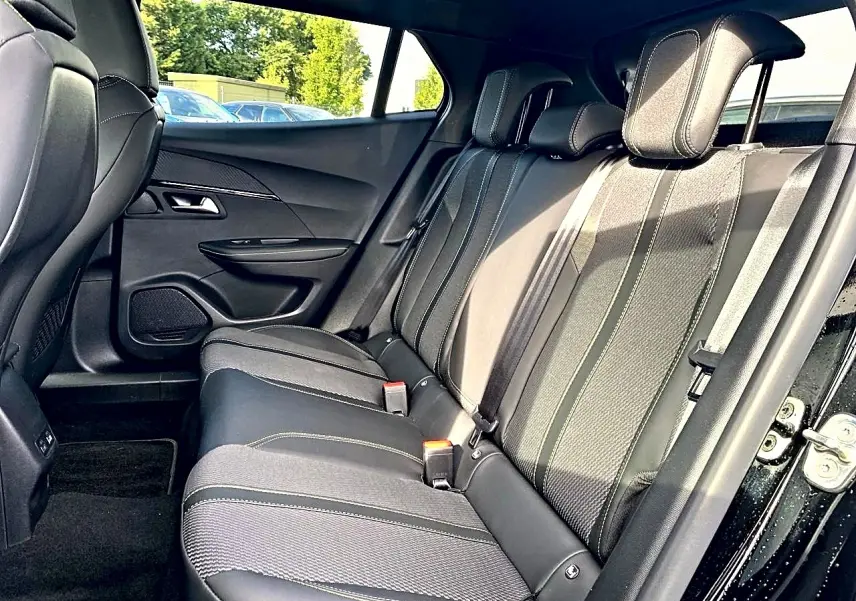 Vue intérieure côté droit des sièges arrière noirs en tissu et cuir du Peugeot 2008 1.2 hybrid 145 GT 2025.