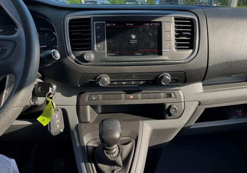 Vue intérieure du tableau de bord du Citroën Jumpy Spacetourer 2022, avec écran tactile, climatisation et levier de vitesses manuel.