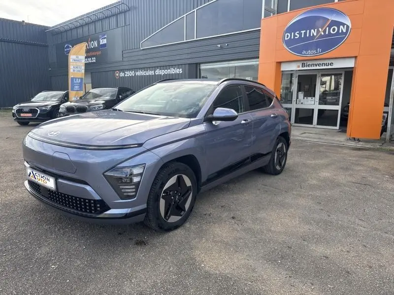 Hyundai KONA Electric 2023 Metal Blue en 3/4 avant droit, avec jantes alu et calandre fermée.