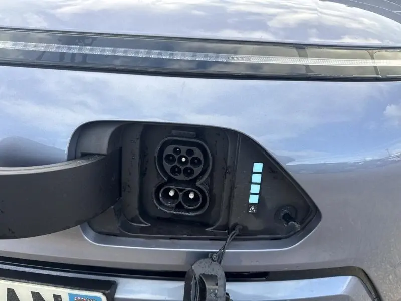 Gros plan sur la prise de recharge avant d’une Hyundai Kona Electric Metal Blue métallisé avec feux LED fins.