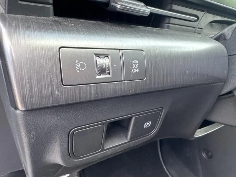 Détail intérieur côté conducteur du Hyundai KONA Electric 2023, montrant les commandes d’éclairage et d’aide à la conduite sur finition Metal Blue.