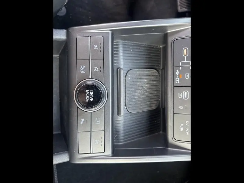 Vue rapprochée de la console centrale noire du Hyundai Kona Electric 2023 avec bouton Drive Mode et commandes tactiles.