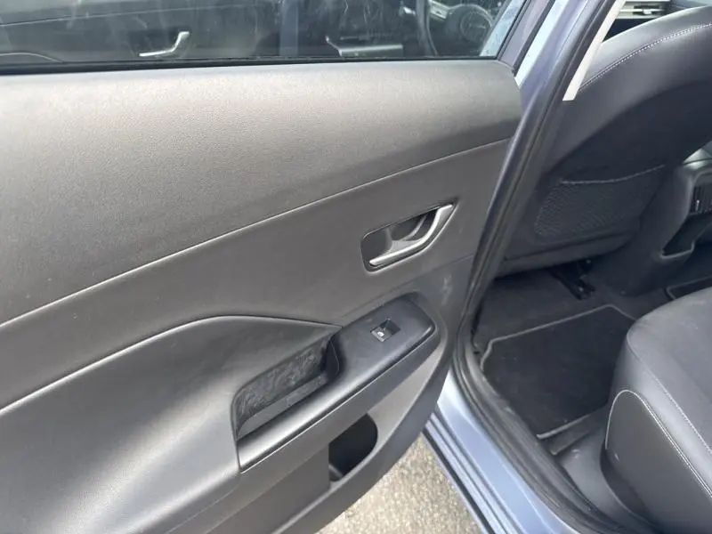 Vue rapprochée de la porte arrière droite intérieure noire du Hyundai Kona Electric 2023 Metal Blue.