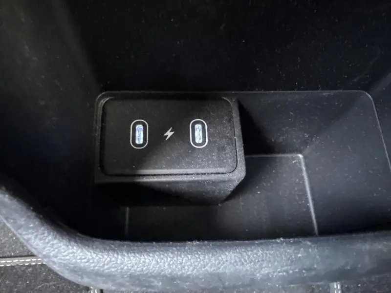 Gros plan sur deux ports USB-C avec symbole d’éclair dans le rangement central d’une Hyundai Kona Electric 2023.