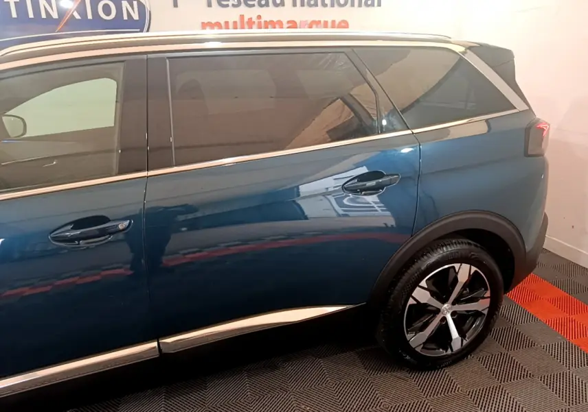 Vue latérale côté droit du Peugeot 5008 bleu 2021 avec jantes alliage et vitres teintées.