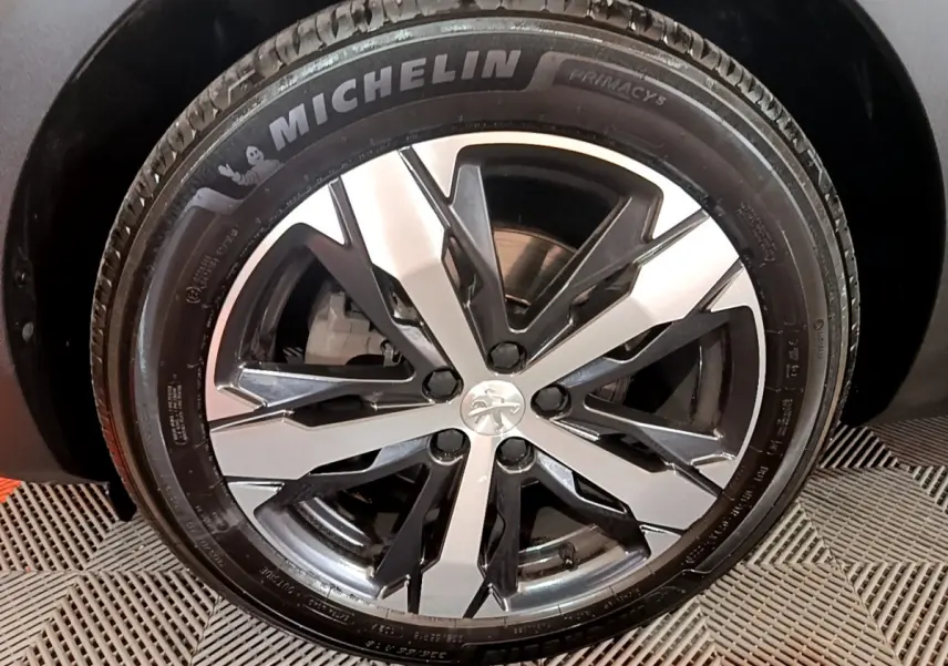 Gros plan sur la jante alliage bicolore et pneu Michelin du Peugeot 5008 PureTech bleu, version GT 2021.