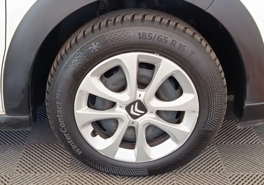 Gros plan sur la roue avant droite d'une Citroën C3 blanche, avec jante en alliage et pneu hiver Continental.