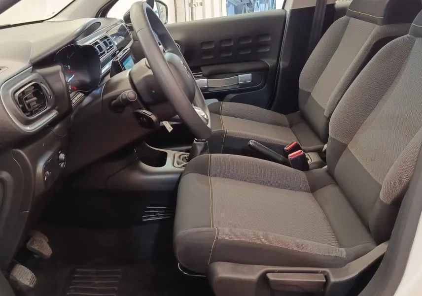 Intérieur avant droit de Citroën C3 blanc 2020, sièges tissu gris et tableau de bord avec écran tactile.