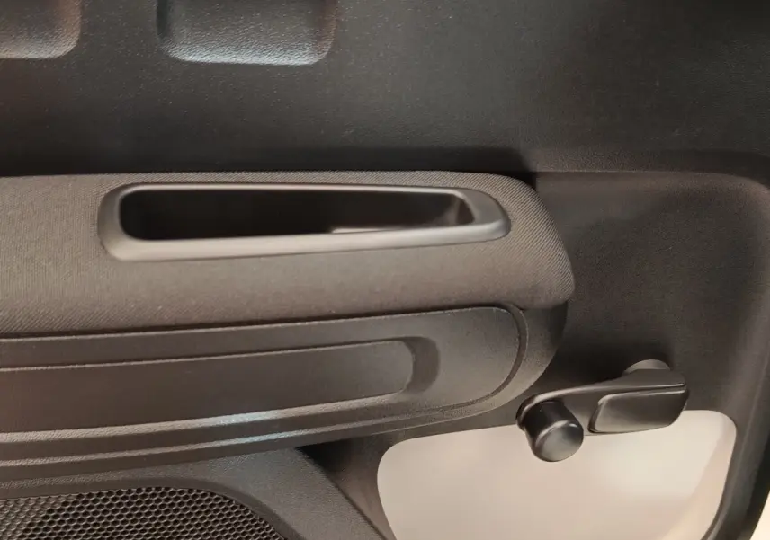 Détail de la poignée intérieure et manivelle de lève-vitre côté droit d’une Citroën C3 blanche 2020.