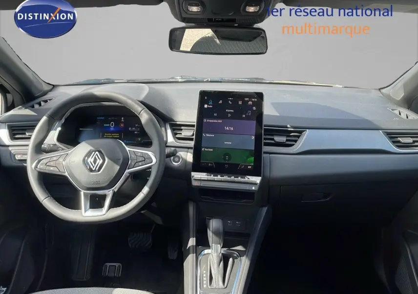 Vue intérieure avant du Renault Captur 2025, tableau de bord noir avec écran tactile vertical et volant multifonction.