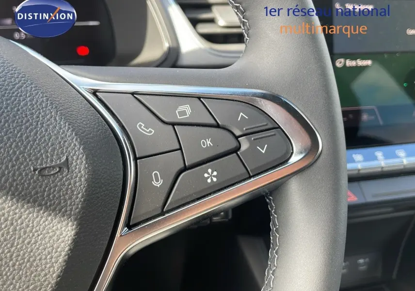 Détail des commandes au volant à droite du Renault Captur 2025, finition noire avec surpiqûres grises.
