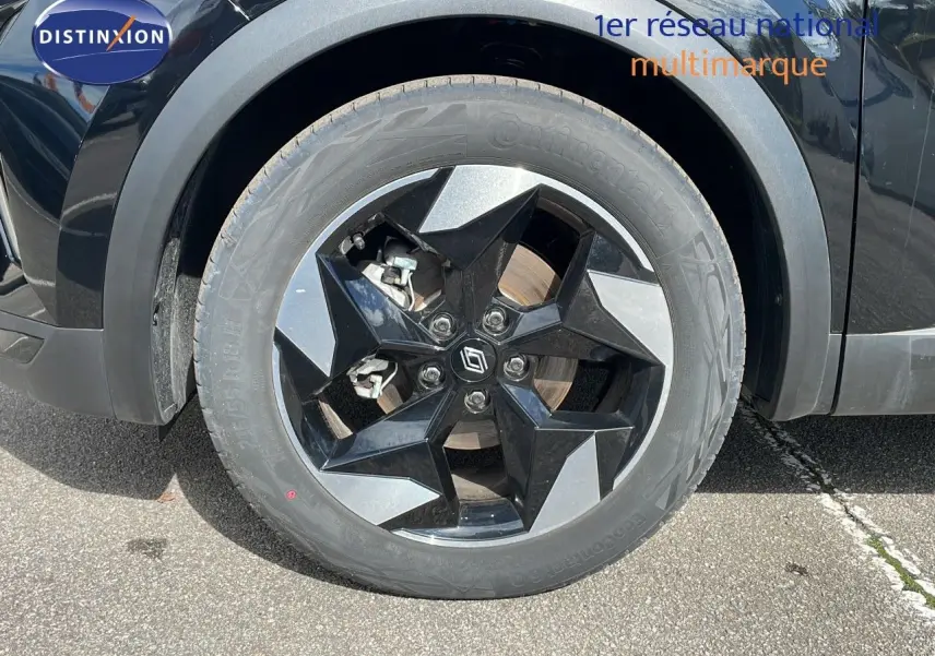 Gros plan sur la roue avant gauche du Renault Captur noir étoile métal avec jante noire et grise au design géométrique.