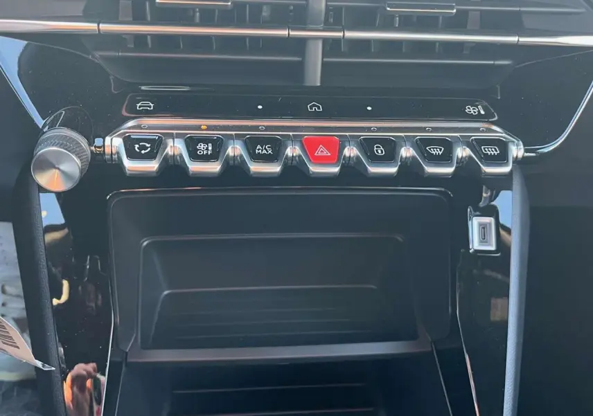Détail de la console centrale du Peugeot 2008 2024 avec boutons de commande et finition noire brillante