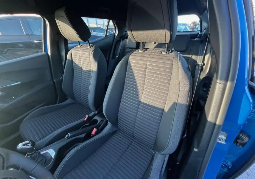 Intérieur du Peugeot 2008 2024 bleu Vertigo Metal, vue côté droit sur les sièges avant en tissu gris et la boîte manuelle.